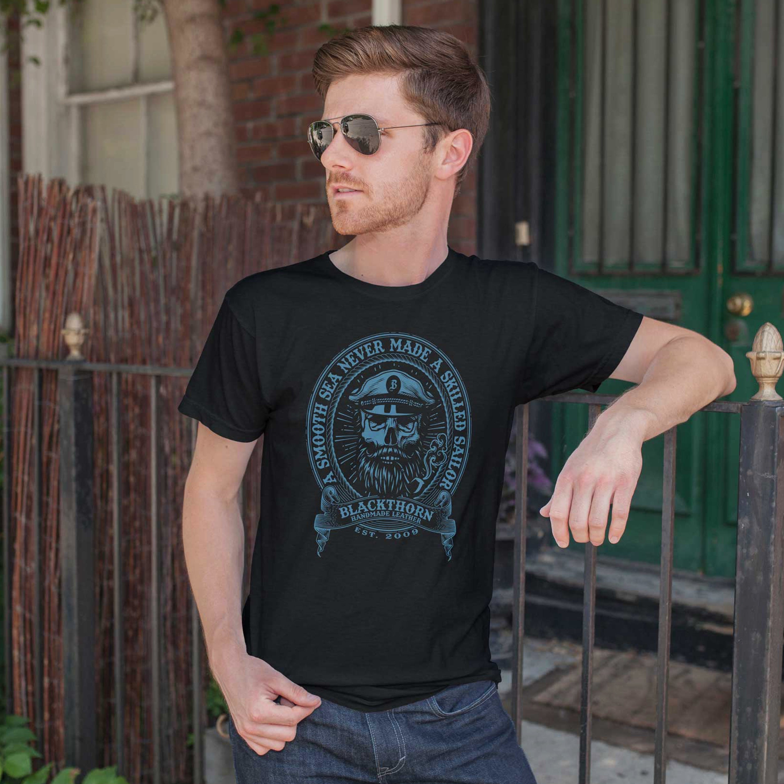 Male model wearing a black "Smooth Seas" t-shirt